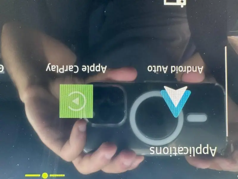 Écran tactile du tableau de bord du Dacia Duster blanc, affichant les options Apple CarPlay et Android Auto.