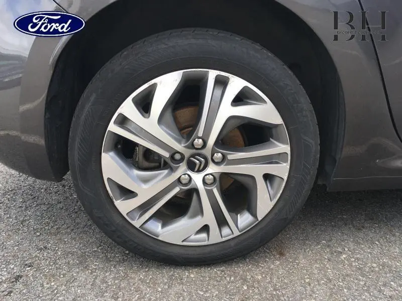 Gros plan sur la jante alu grise Shark d'une Citroën C4 Picasso 2016, mettant en valeur le logo Citroën central.