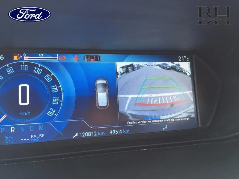 Affichage numérique du tableau de bord avec caméra de recul et indicateurs de vitesse et distance, intérieur du véhicule.