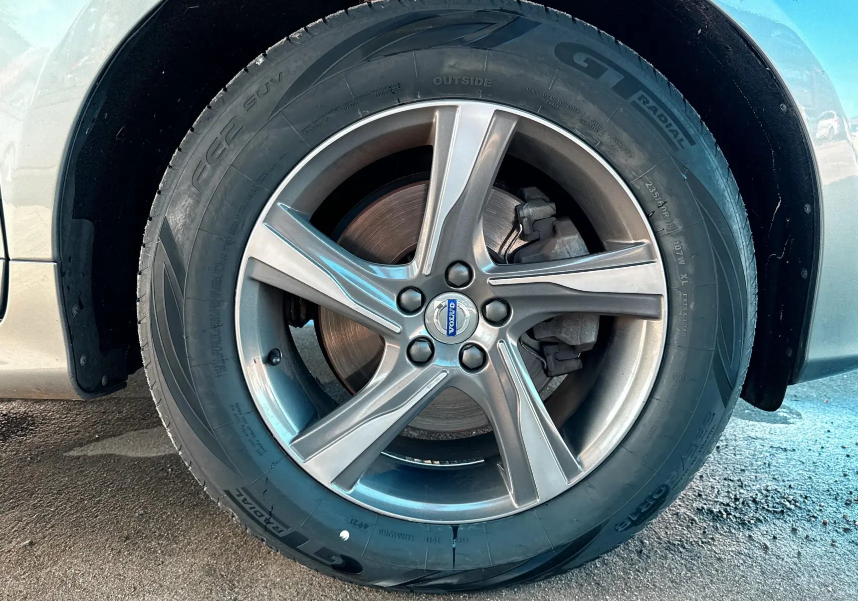 Gros plan sur la roue avant gauche grise du Volvo XC60 D4 2016 avec jante alliage cinq branches et pneu GT Radial.