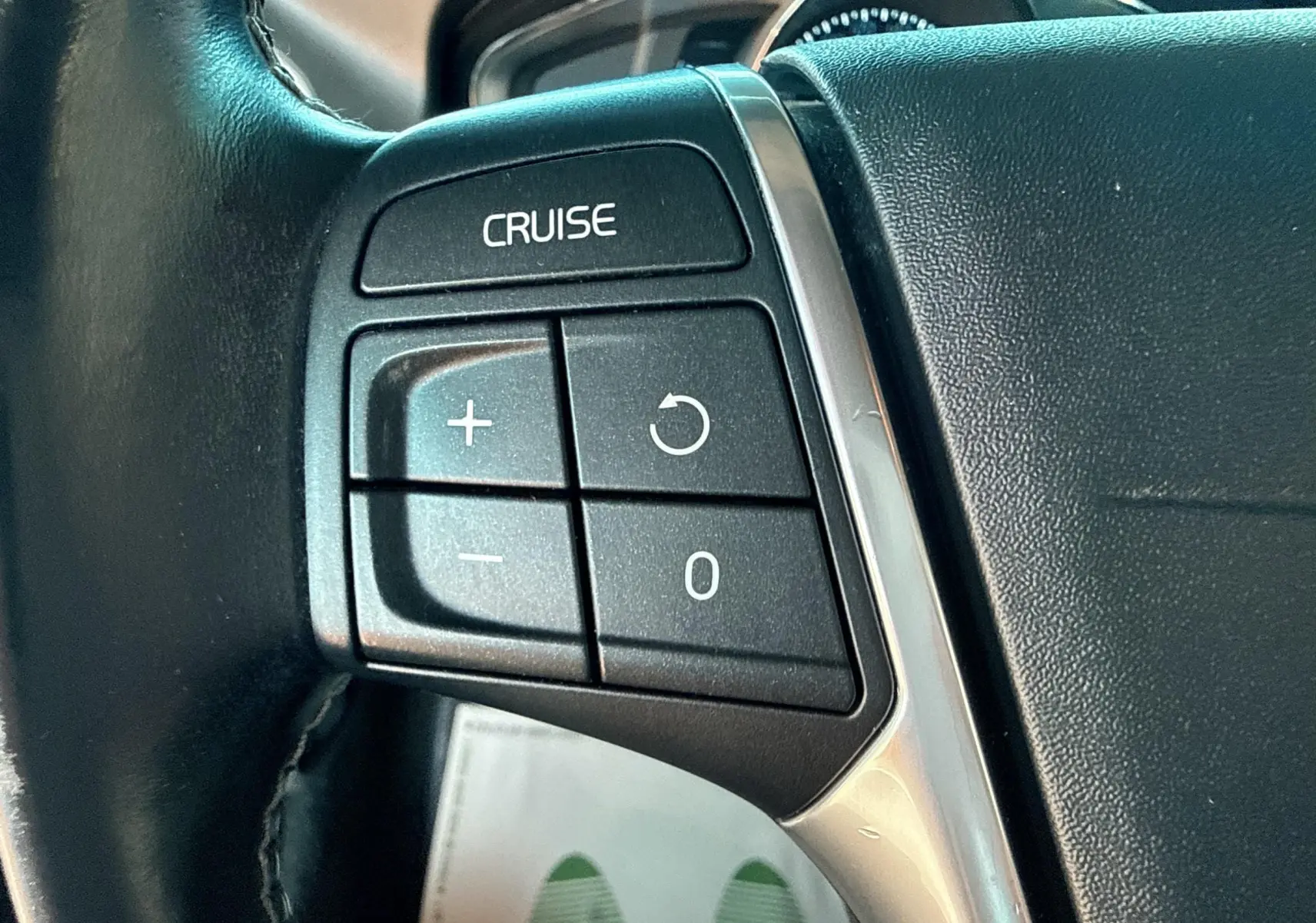 Gros plan sur les commandes de régulateur de vitesse au volant noir du Volvo XC60 gris 2016 D4 Momentum.