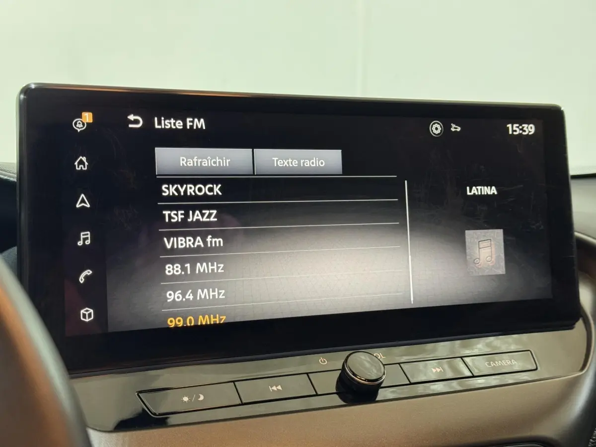 Écran tactile central du Nissan Juke gris clair 2025 affichant la liste des stations radio FM