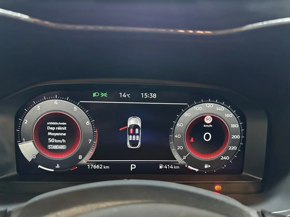 Vue rapprochée du combiné d'instruments numérique du Nissan Juke gris clair, affichant vitesse, régime et alertes.