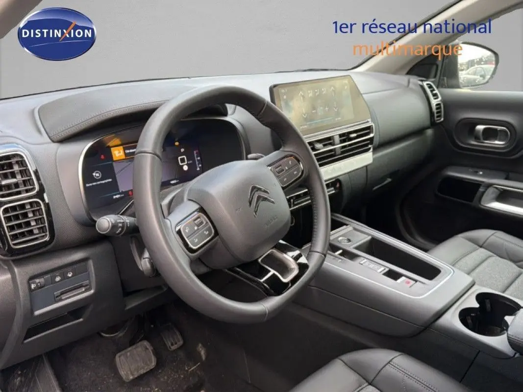 Intérieur du Citroën C5 Aircross Hybrid 2025 vu côté conducteur, tableau de bord moderne et volant multifonction noir.