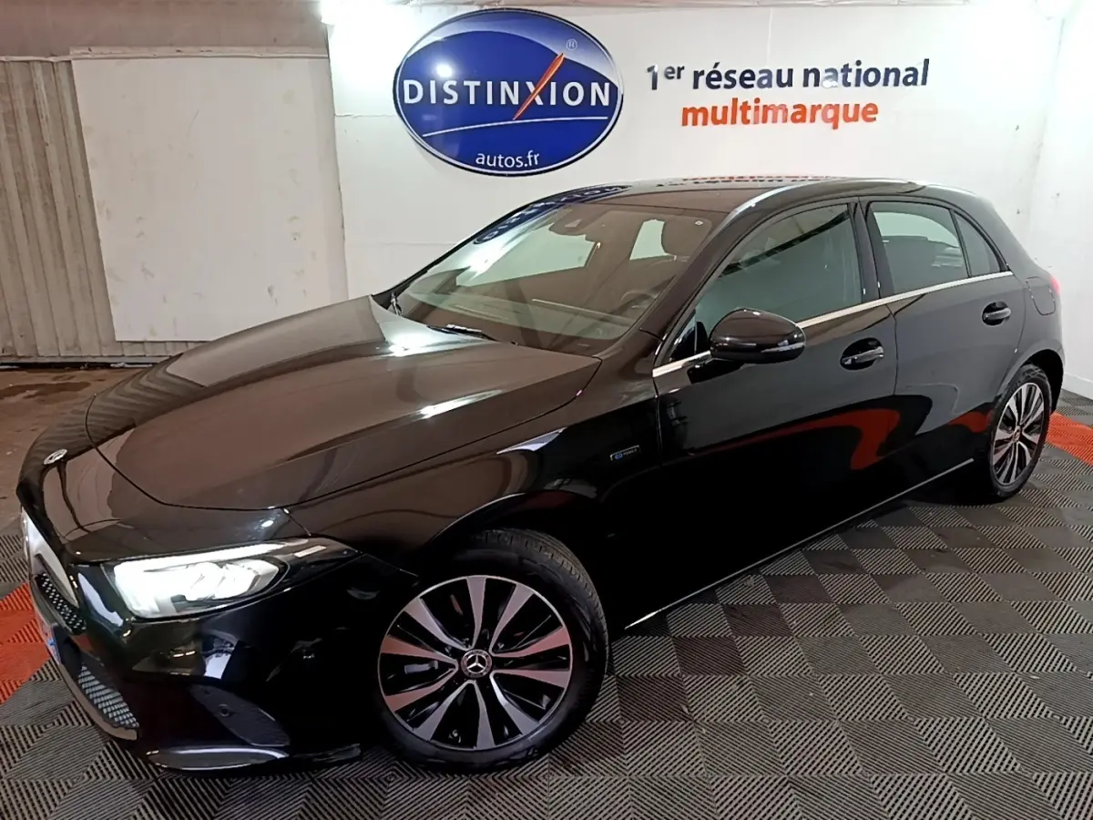 Vue 3/4 avant droite d'une Mercedes Classe A noire brillante dans un showroom avec éclairage intérieur.