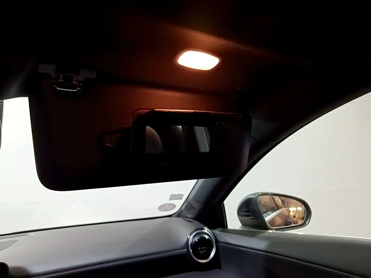 Vue intérieure côté passager avant du Mercedes Classe A 250 e Business Line 2020, avec pare-soleil abaissé et miroir éclairé.