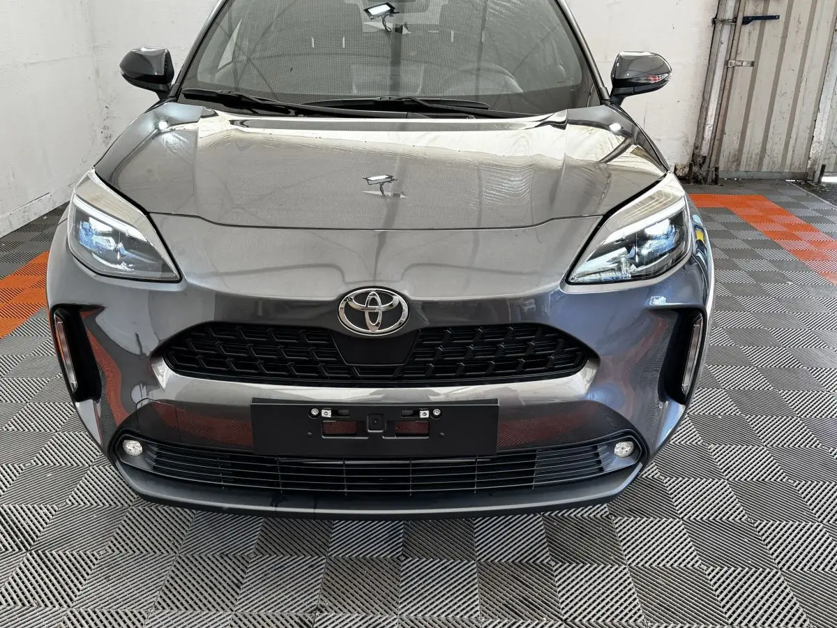 Vue frontale d'une Toyota Yaris Cross 2026 gris foncé avec phares LED et calandre noire distinctive.
