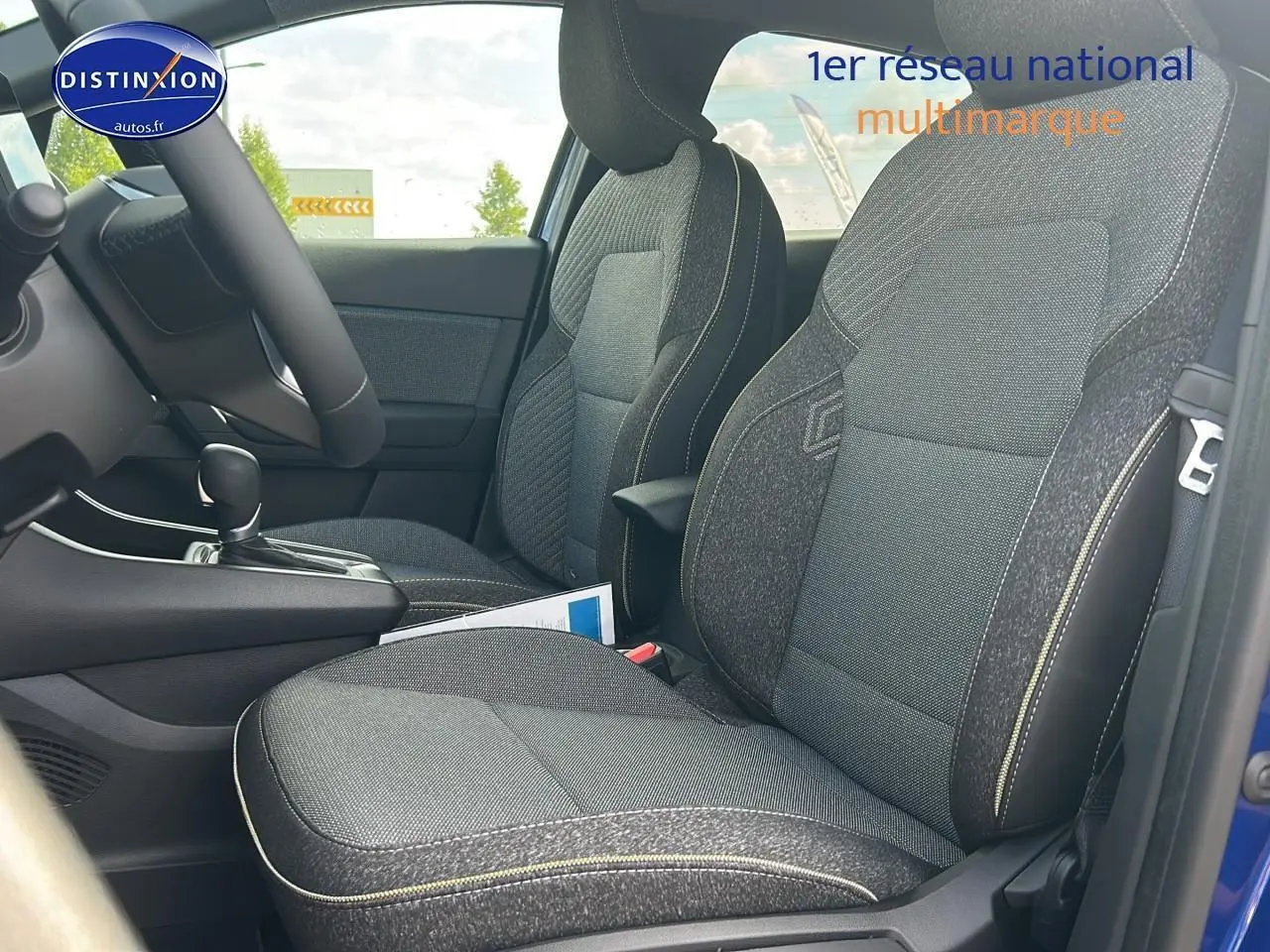 Intérieur du Renault Captur 2025 bleu iron, vue côté droit sur sièges avant en tissu gris avec surpiqûres claires.