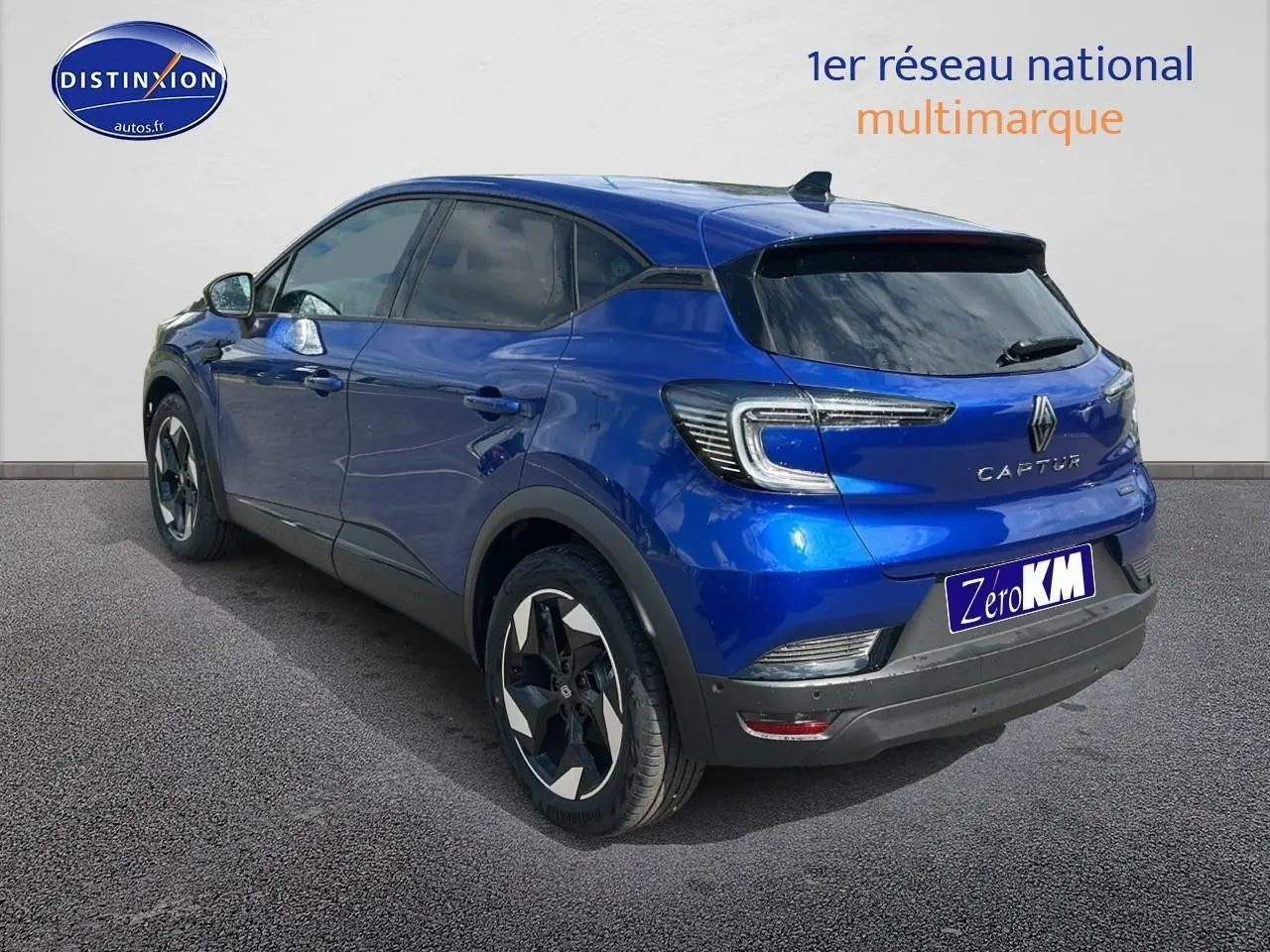 Vue 3/4 arrière droite d'un Renault Captur bleu iron avec jantes alu et vitres arrière surteintées.