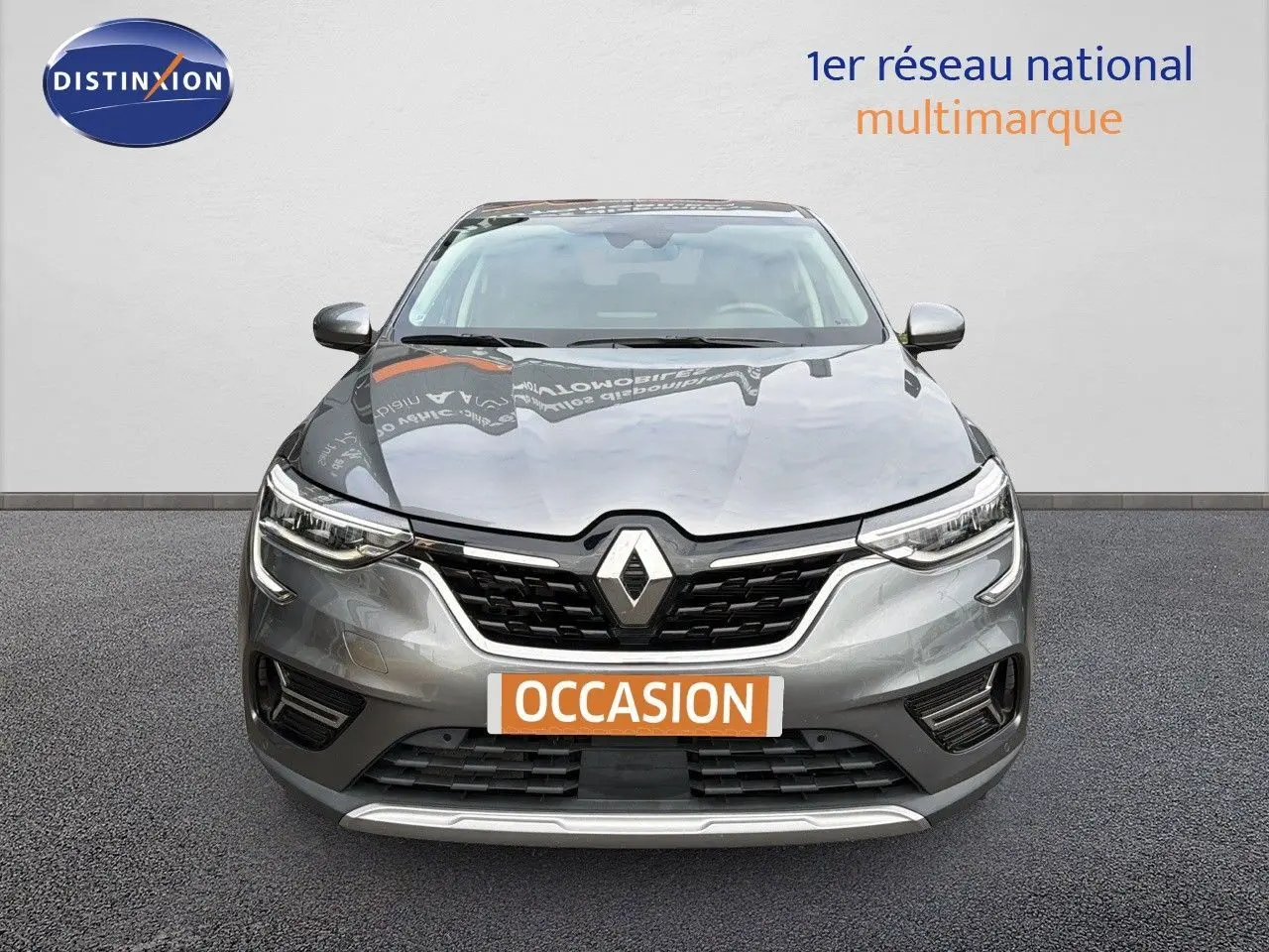 Vue frontale d'une Renault Arkana gris métallisé 2022 avec calandre noire et logo Renault proéminent.