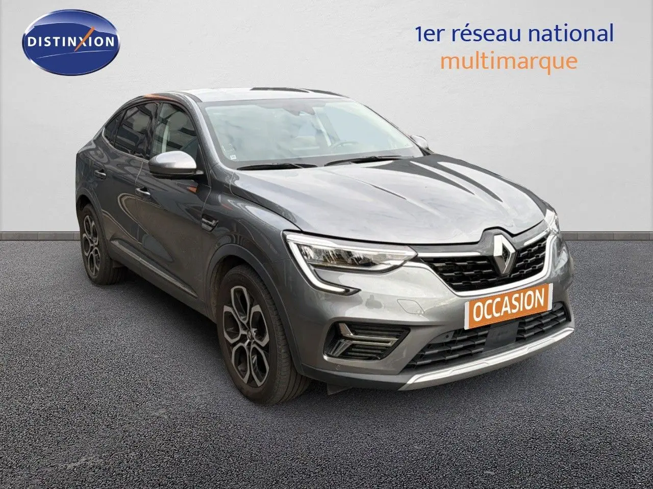 Renault Arkana gris 3/4 avant droit avec jantes bi-ton et calandre noire, sur fond neutre showroom.