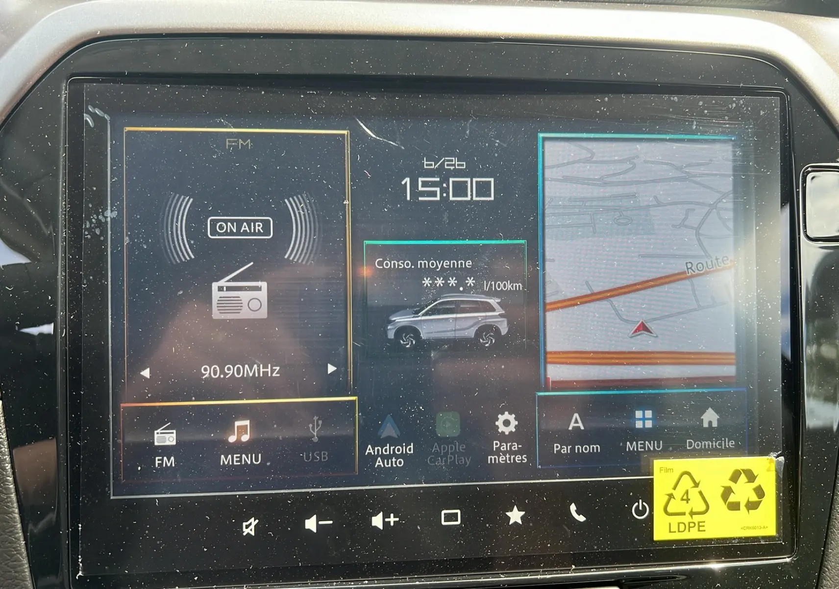 Écran tactile central du Suzuki Vitara 2025 en silky silver, affichant radio FM, consommation moyenne et navigation.