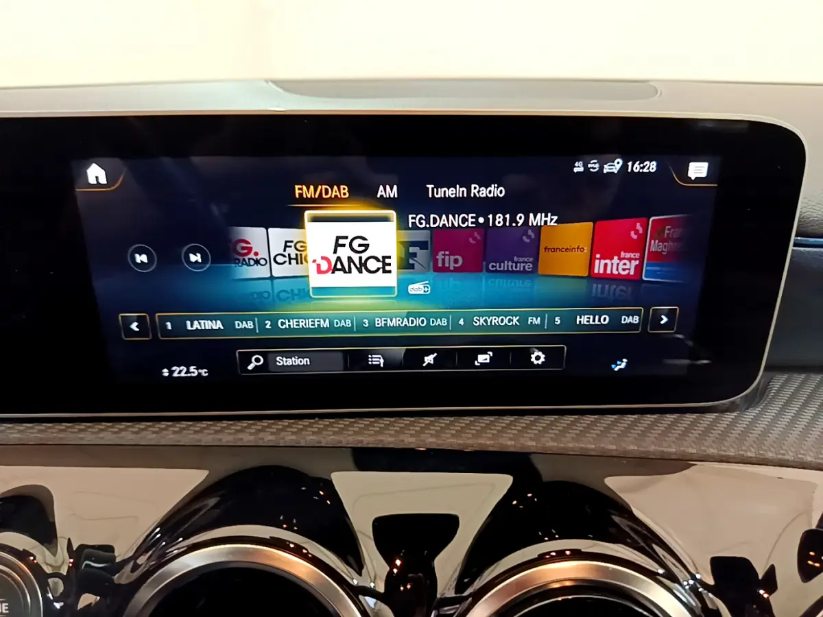 Écran tactile central affichant la radio FM/DAB dans l'habitacle d'une Mercedes Classe A gris clair, vue de face.