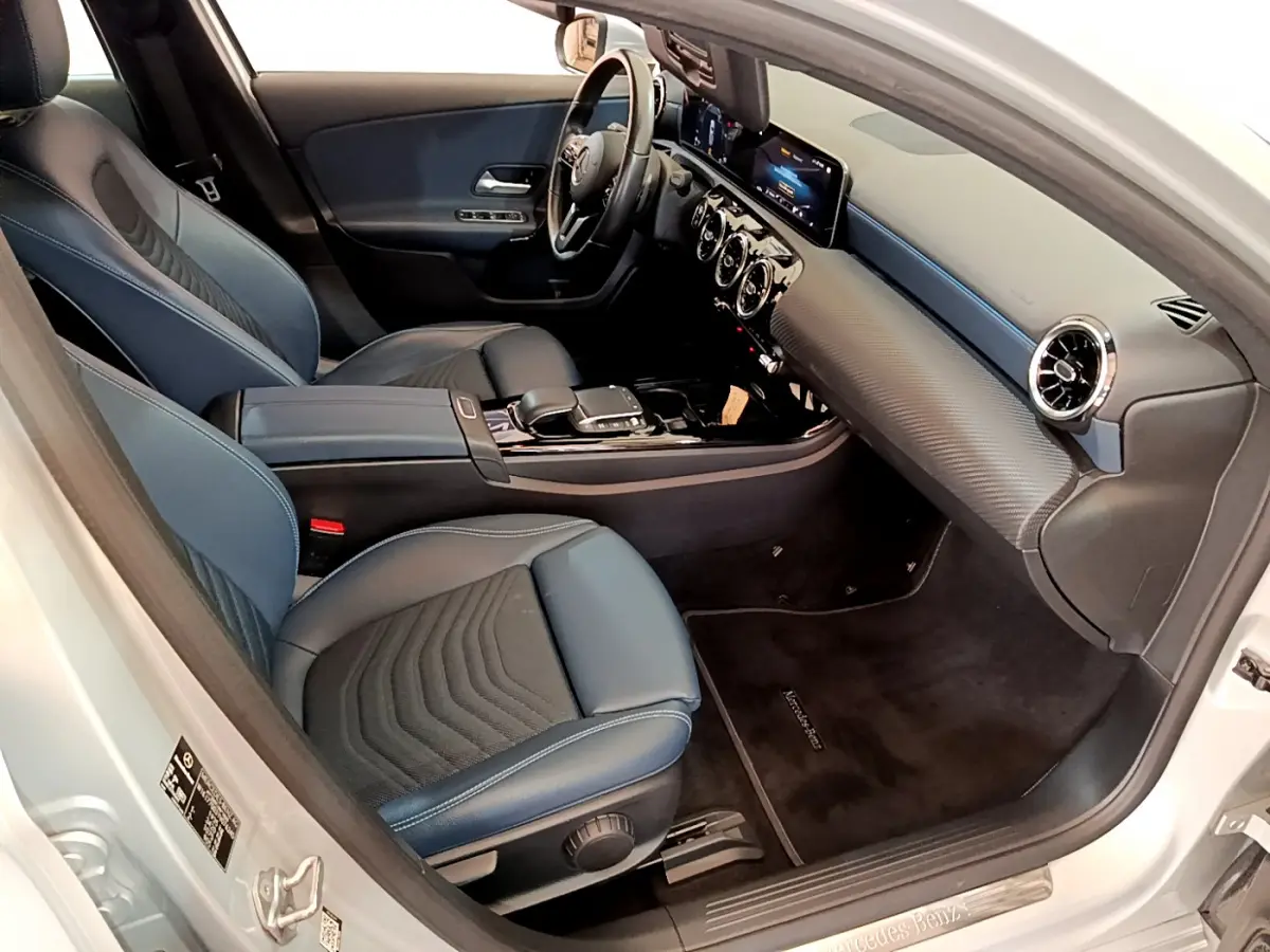 Vue intérieure côté conducteur de la Mercedes Classe A 180 d Business Line 2020 avec sièges cuir bleu et tableau de bord moderne.
