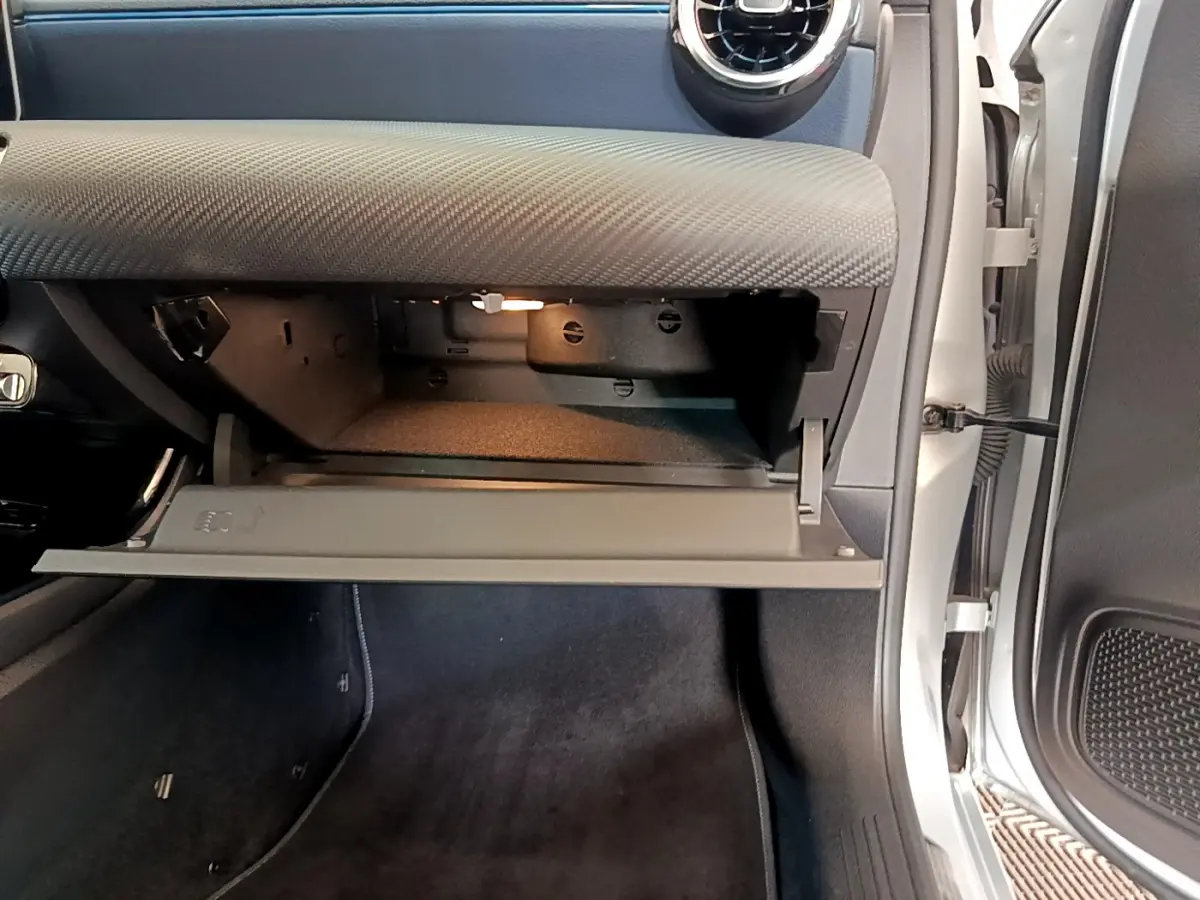 Vue intérieure côté passager montrant la boîte à gants ouverte et le tableau de bord gris clair d'une Mercedes Classe A 180 d 2020.