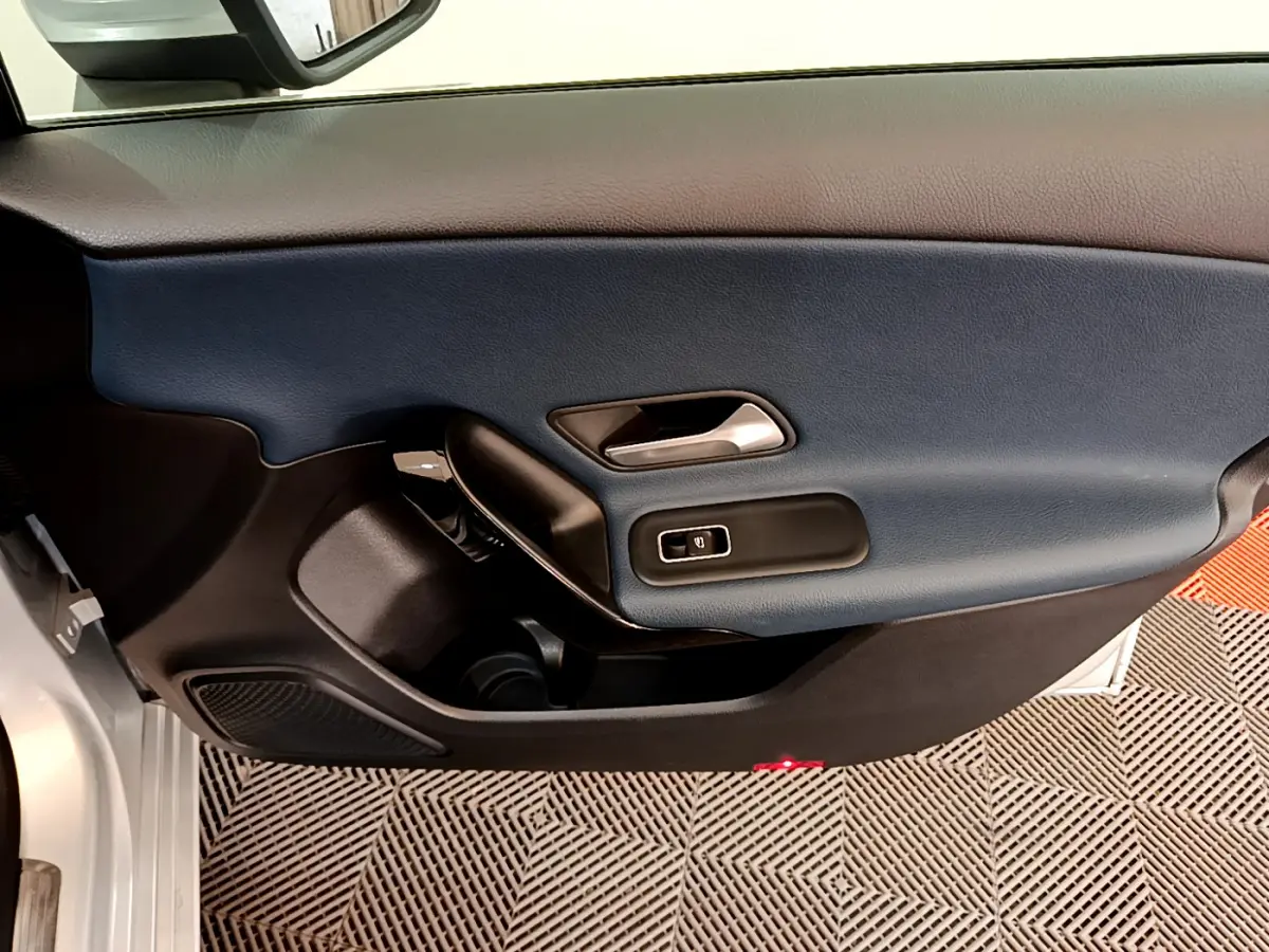 Vue rapprochée de la porte côté conducteur d’une Mercedes Classe A 180 d Business Line 2020 avec garniture bleu foncé et gris clair.
