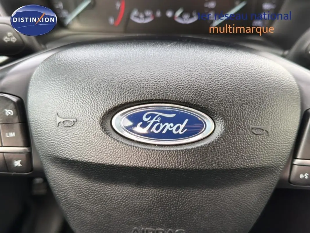 Gros plan sur le volant noir avec logo Ford au centre du Ford Puma blanc, version Titanium 2020.