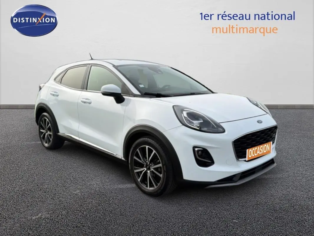 Ford Puma blanc en 3/4 avant droit avec jantes alliage noires et vitres surteintées, sur fond neutre.