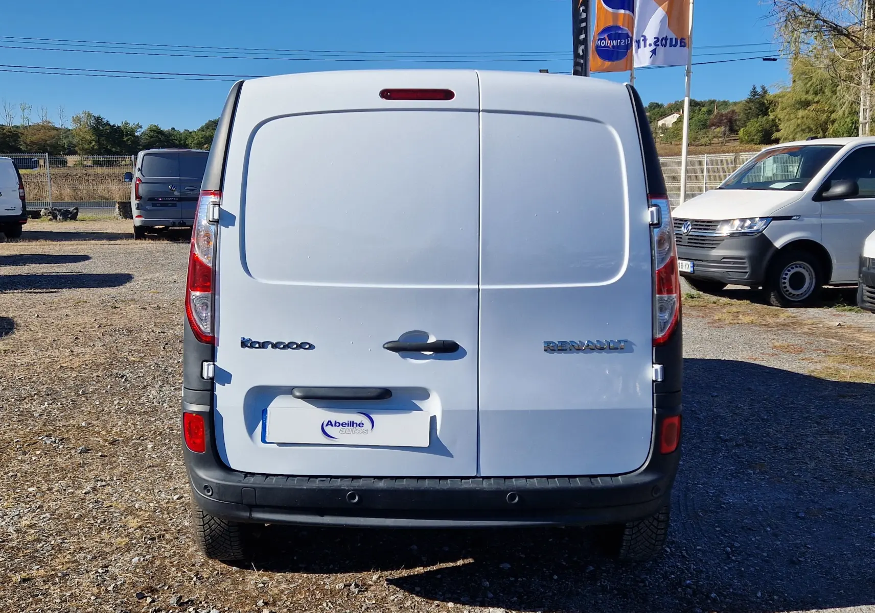 Vue arrière d’un Renault Kangoo blanc 2021, fourgon compact avec portes battantes et logo visible sur un parking extérieur.