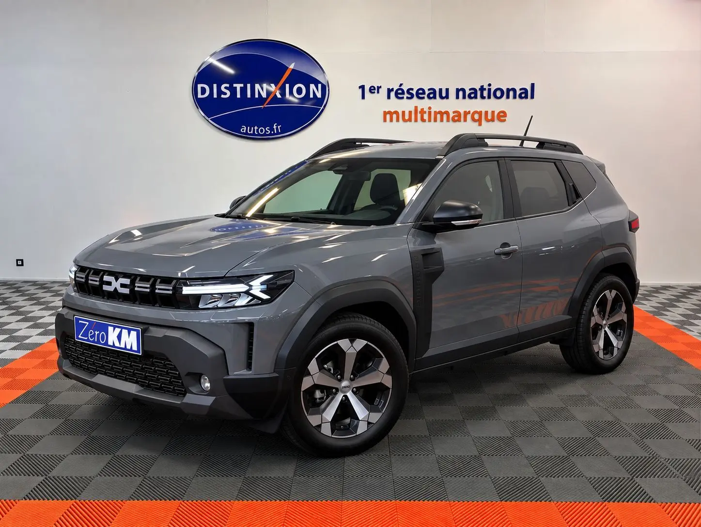 Dacia Duster 1.8 Full Hybride gris schiste en 3/4 avant droit, avec jantes alliage et calandre moderne.