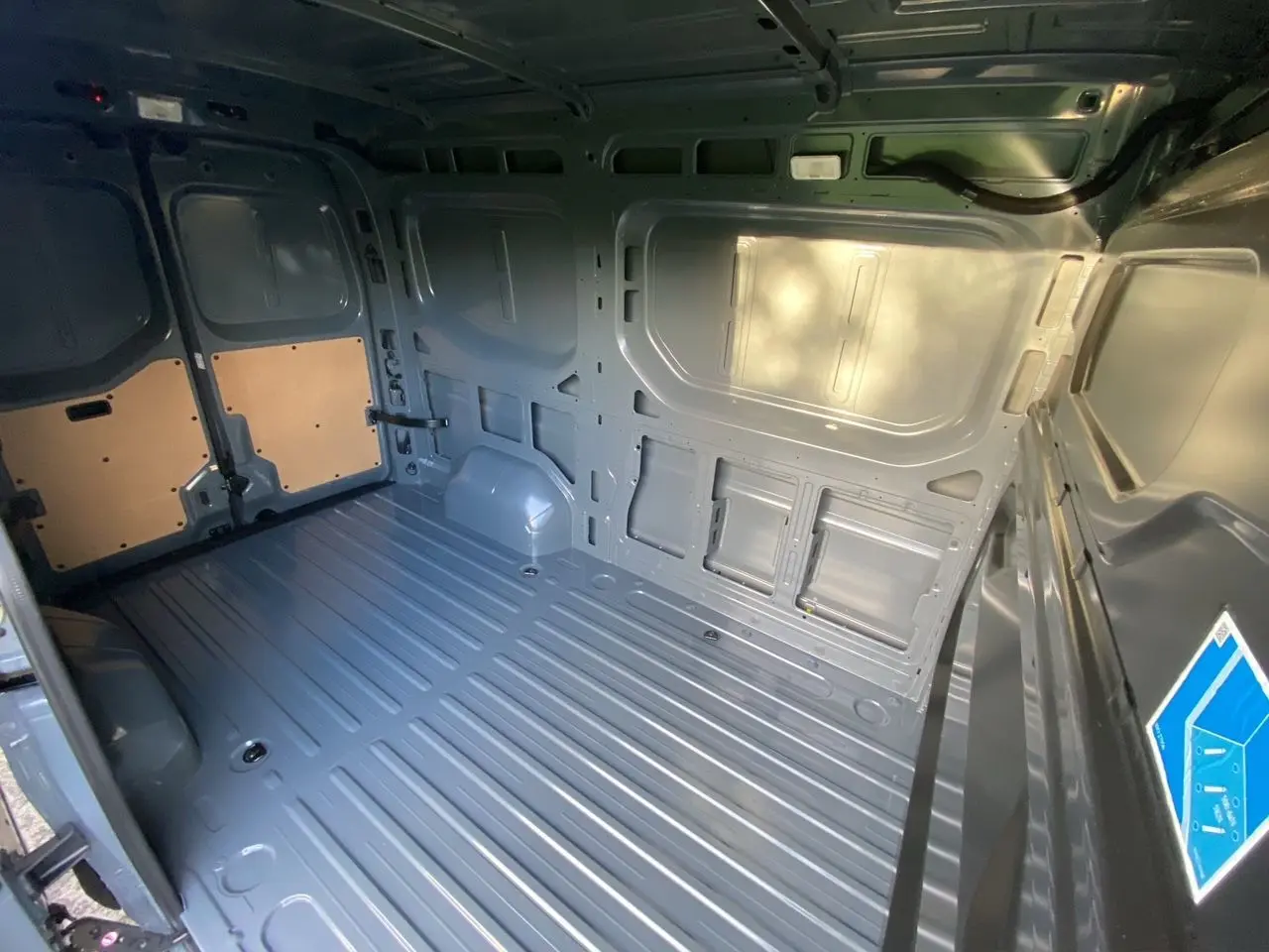 Vue intérieure arrière du Renault Master 2025 gris urbain, montrant l’espace de chargement tôlé et le plancher métallique.