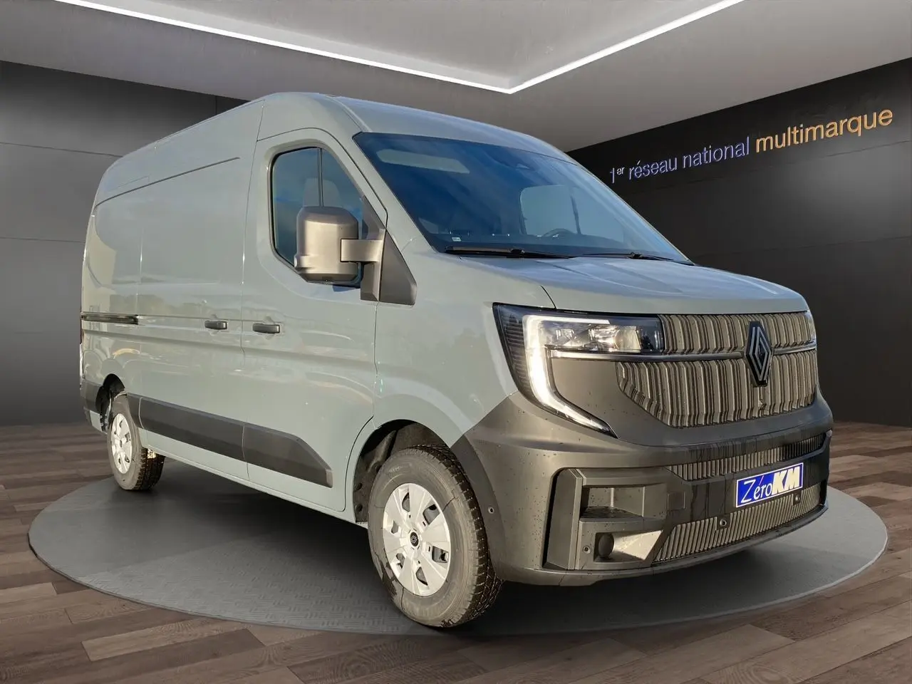 Renault Master gris urbain en vue 3/4 avant droit, avec calandre noire et roues équipées de pneus tous temps.