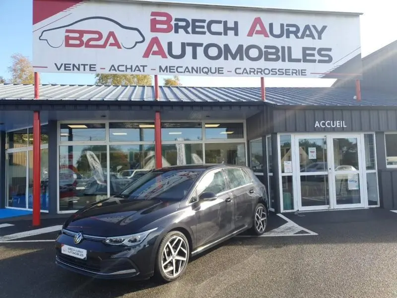 Volkswagen Golf 1.5 eTSI Style noir nacré vue 3/4 avant droit devant un garage Brech Auray Automobiles