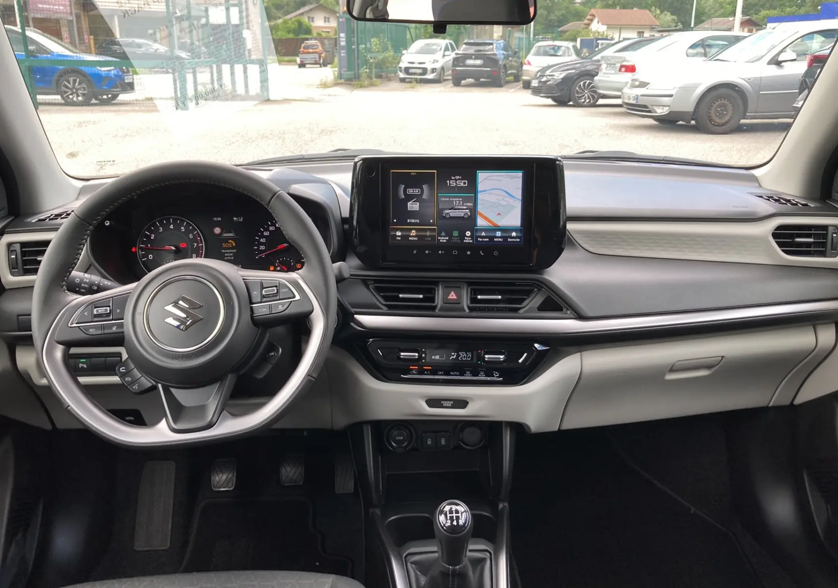 Intérieur moderne de Suzuki Swift 2025, vue frontale du tableau de bord avec écran tactile et volant multifonctions cuir.