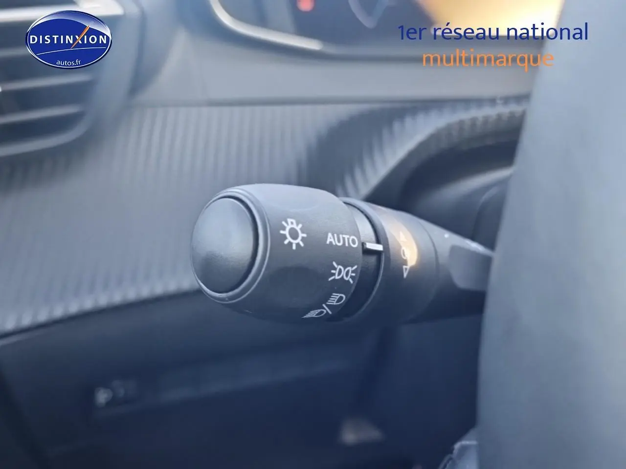 Gros plan sur la commande des phares automatiques dans l'habitacle gris de la Peugeot 208 1.2 100 Allure 2025.