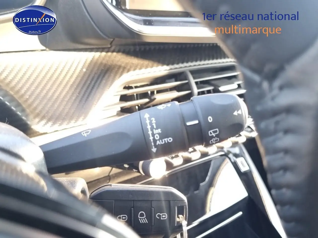 Gros plan sur la commande d’essuie-glace côté gauche du tableau de bord d’une Peugeot 208 gris Artense.