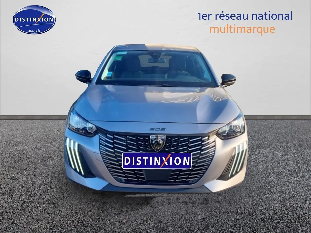 Vue avant d'une Peugeot 208 1.2 100 Allure gris Artense avec feux diurnes LED en forme de griffes visibles.