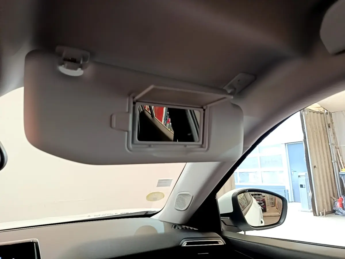 Intérieur du Peugeot 2008 blanc 2021, vue sur pare-soleil avec miroir et rétroviseur côté droit visible.