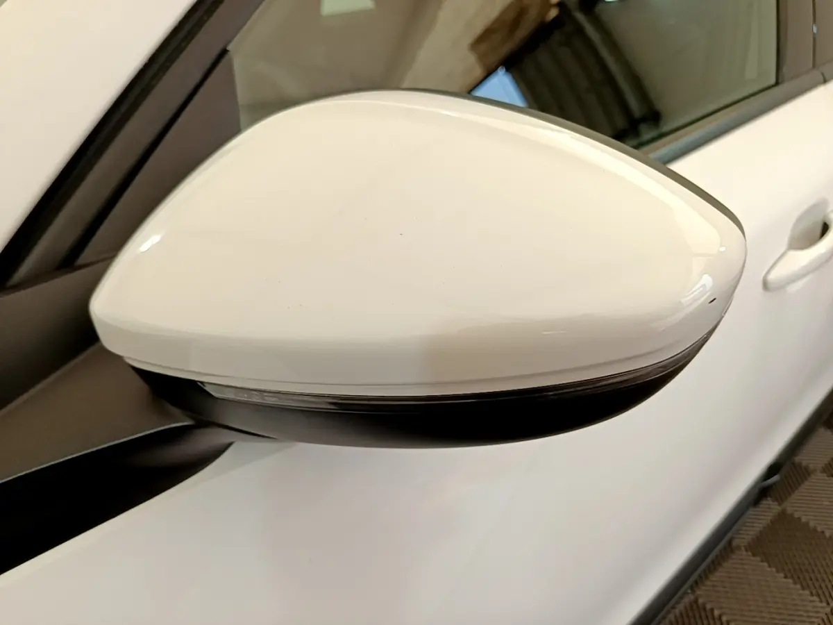 Rétroviseur droit blanc de Peugeot 2008 2021 vue rapprochée avec clignotant intégré sur carrosserie blanche.