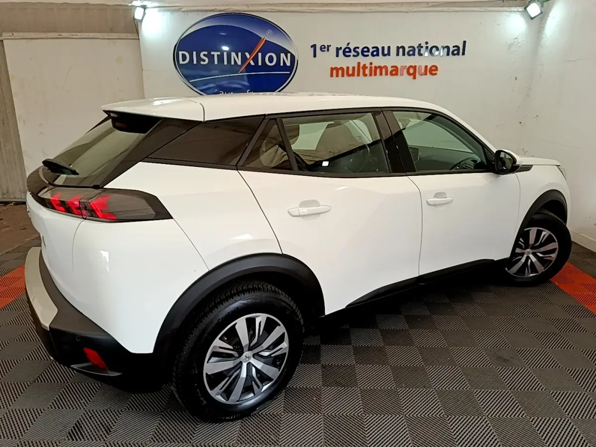 Vue 3/4 arrière droite d’un Peugeot 2008 blanc avec feux arrière LED et jantes alliage en showroom.