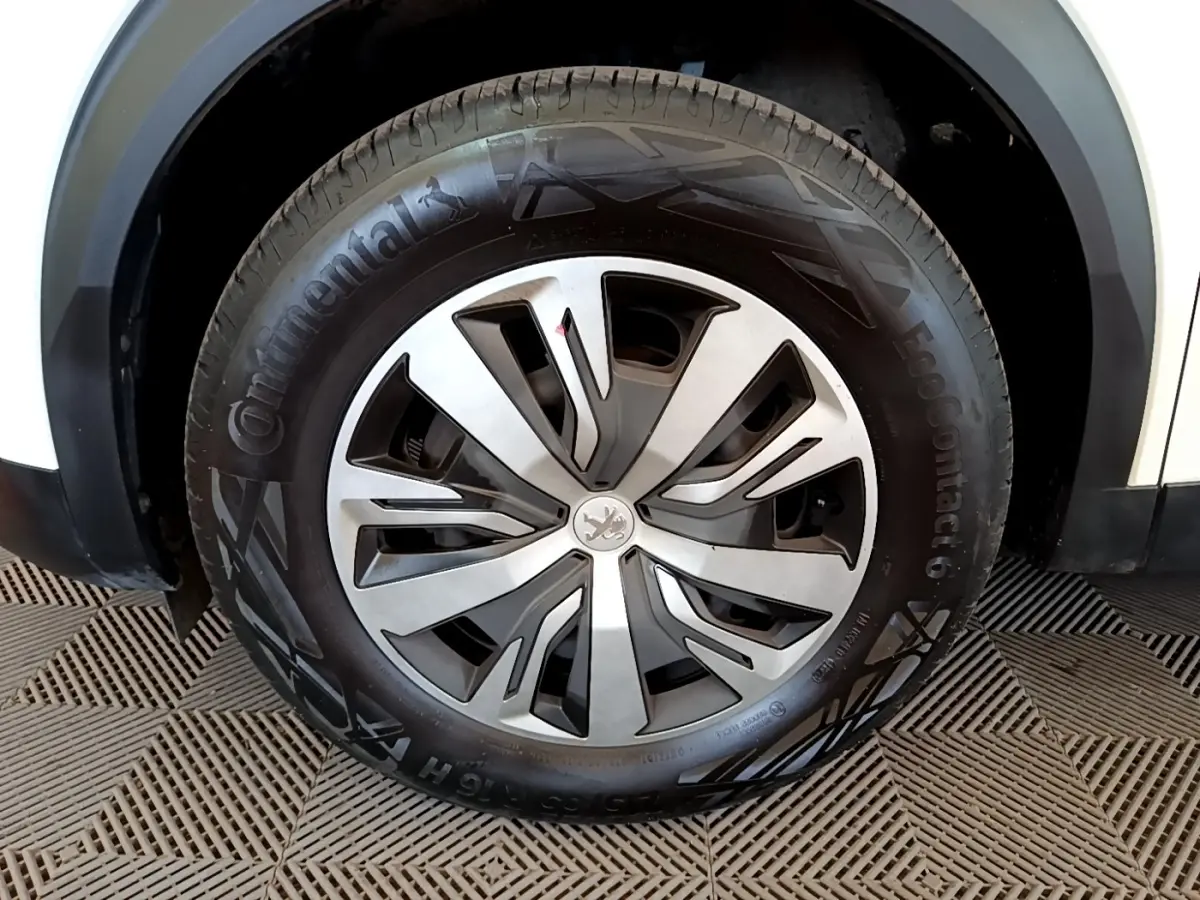 Gros plan sur la roue avant droite blanche d’un Peugeot 2008 2021 avec jante en alliage et pneu Continental.