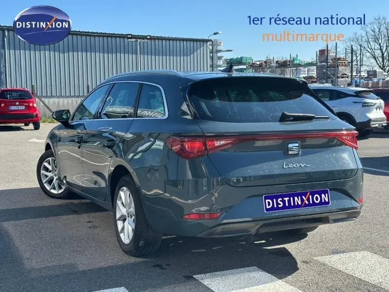 Vue 3/4 arrière droite d'une SEAT LEON ST 2.0 TDI 115ch STYLE XL bleu saphir métallisé, en extérieur sur parking.