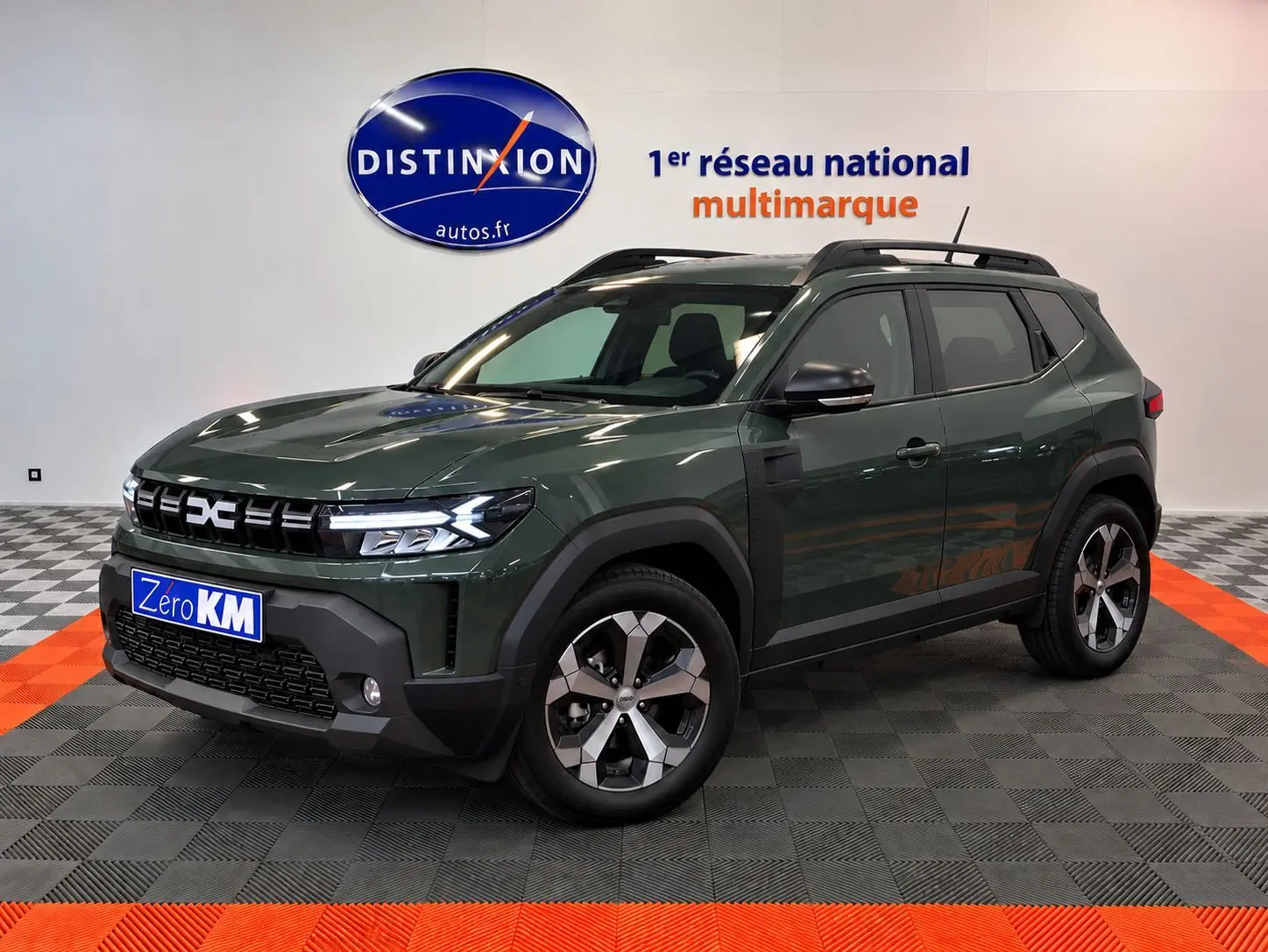 SUV Dacia Duster 2026 vert cèdre en 3/4 avant droit, avec jantes alliage et calandre noire distinctive.