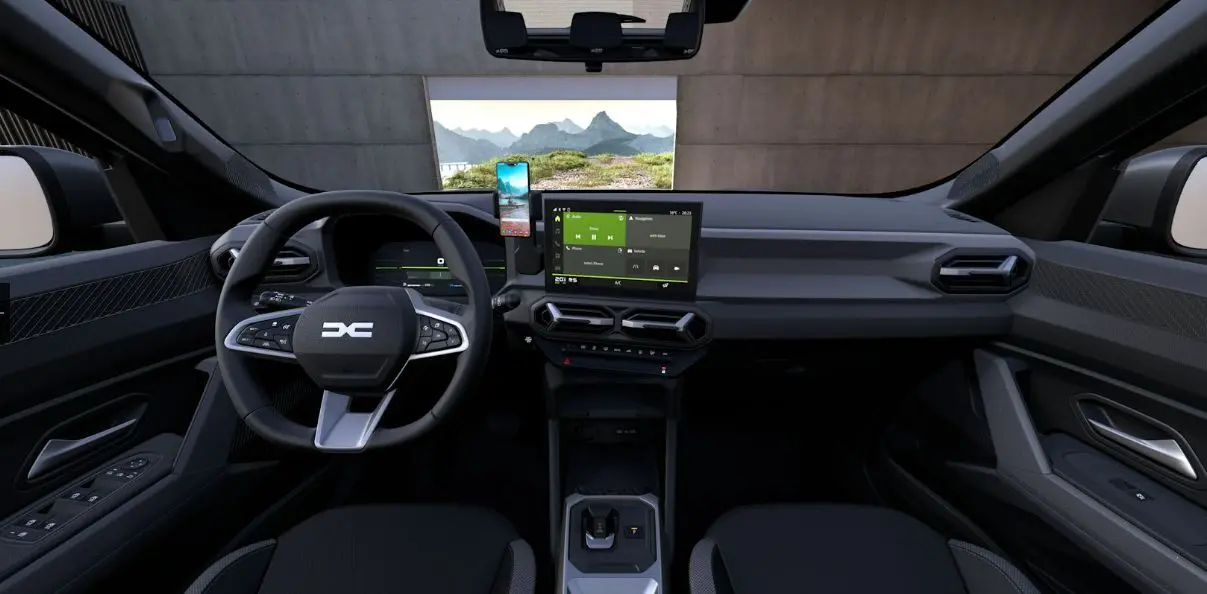 Vue intérieure frontale du tableau de bord du Dacia Duster 2026, avec écran tactile central et volant multifonction noir.