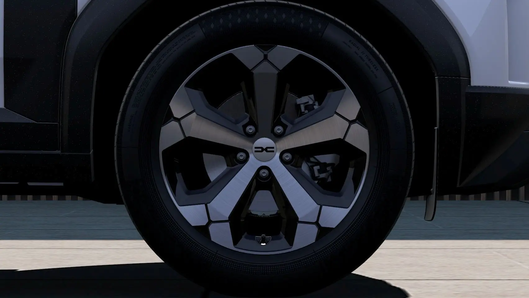 Gros plan sur la roue avant droite du Dacia Duster 2026, jante alliage bicolore noire et argent.