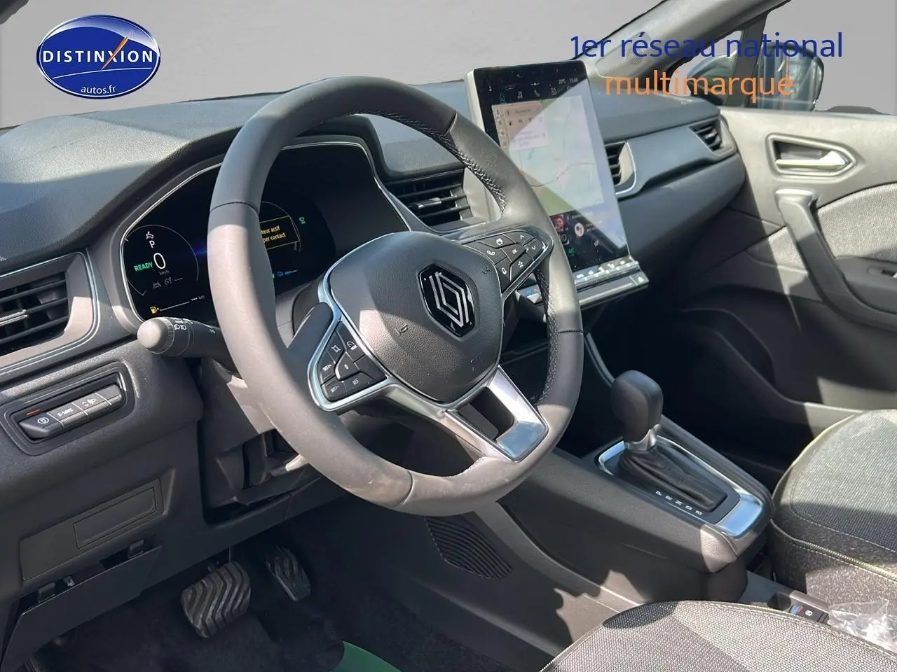 Intérieur Renault Captur 1.6 e-tech hybride 2025 vu côté conducteur, volant multifonction et écran tactile vertical.