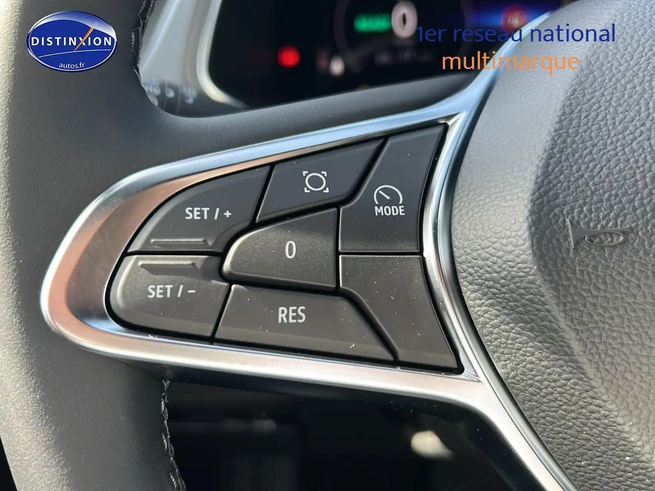 Gros plan sur les commandes multifonctions à gauche du volant cuir du Renault Captur noir étoile 2025 hybride.