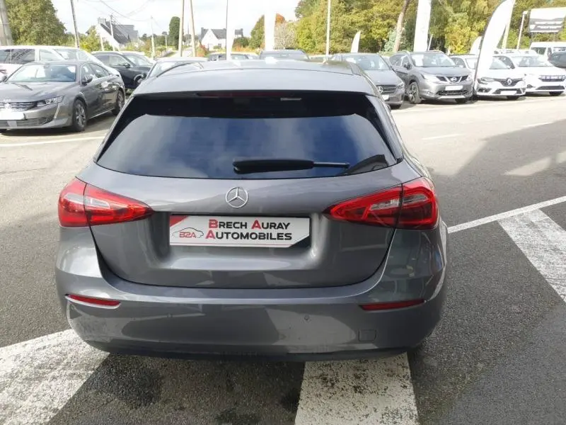 Vue arrière d'une Mercedes Classe A gris montagne métallisé avec feux arrière LED et vitre teintée sur parking.