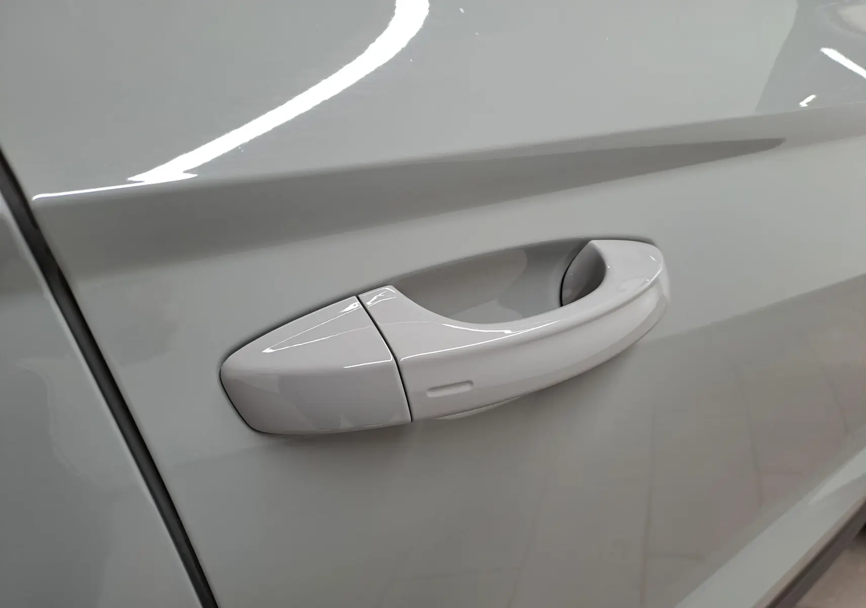 Poignée de porte côté gauche du SKODA KAROQ gris perle 2023, vue rapprochée sur la finition lisse et brillante.