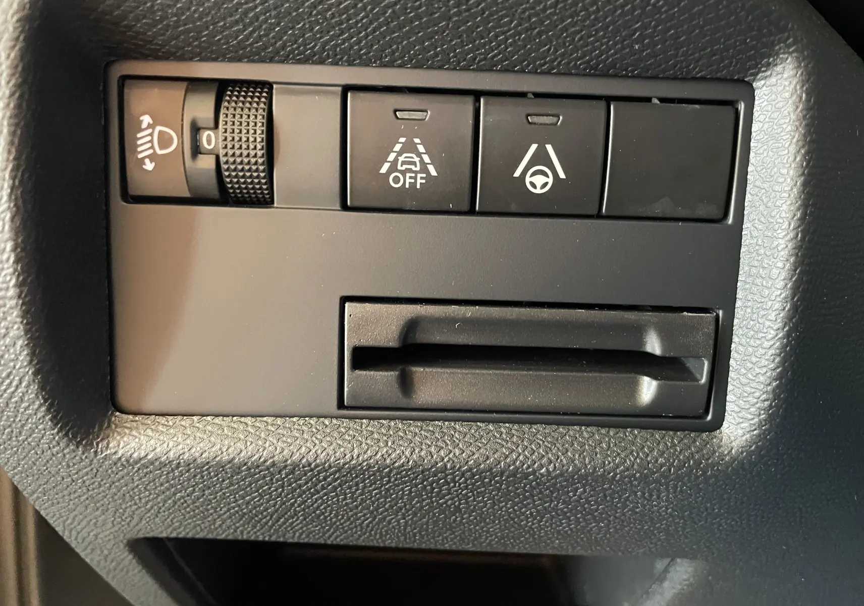 Gros plan sur les commandes noires du tableau de bord du Citroën C5 Aircross gris platinium, boutons d'assistance à la conduite visibles.