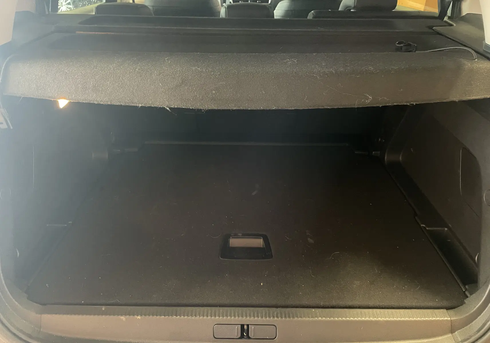 Coffre ouvert vu de l'arrière du Citroën C5 Aircross gris platinium, montrant l'espace de chargement vide avec cache-bagages.