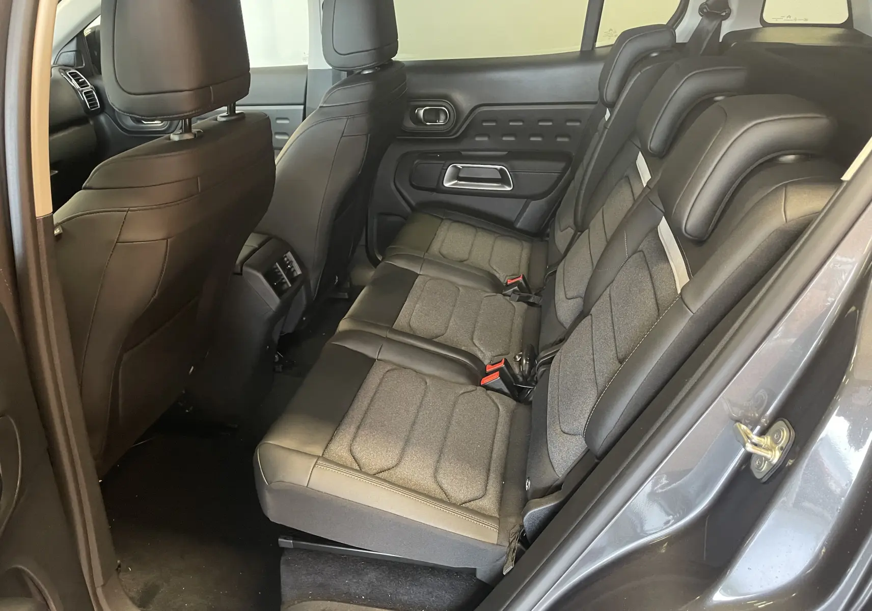 Vue intérieure côté droit des sièges arrière en tissu et cuir du Citroën C5 Aircross hybride gris platinium 2025.