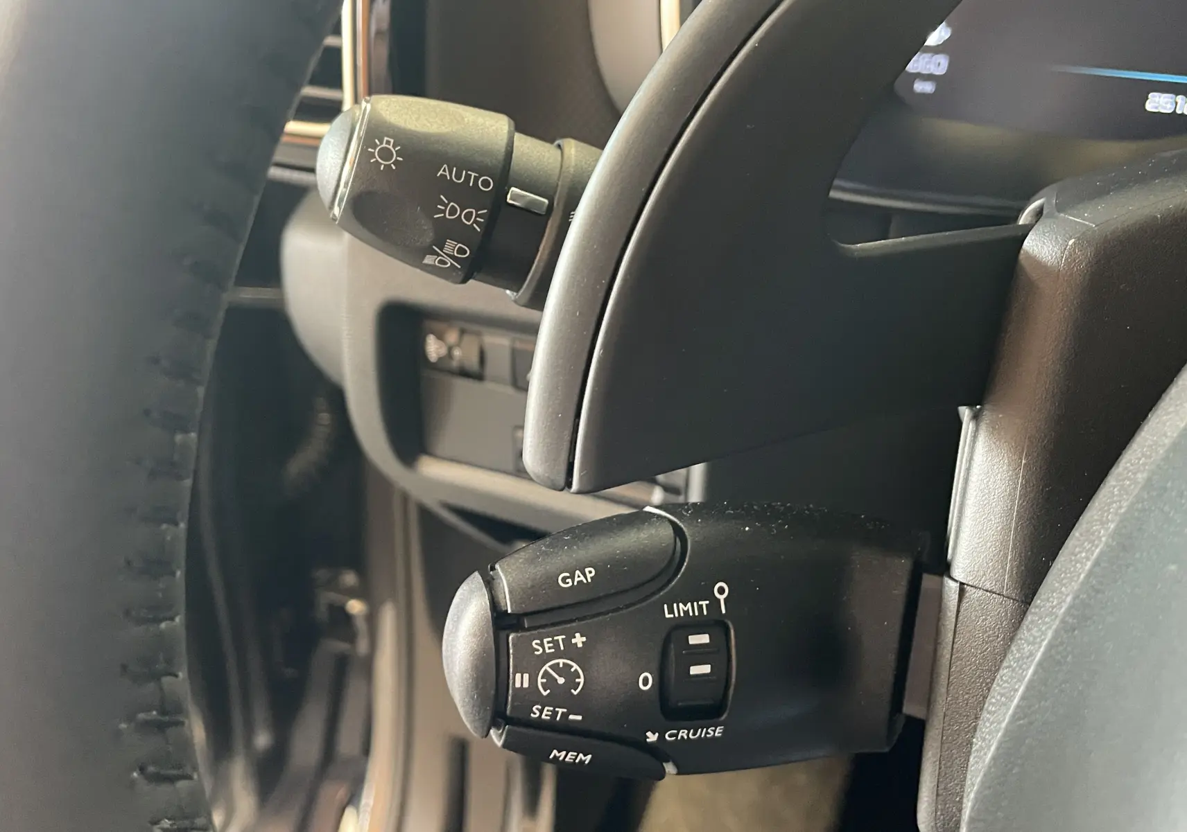 Gros plan sur les commandes au volant du Citroën C5 Aircross gris platinium, mettant en valeur le régulateur de vitesse.