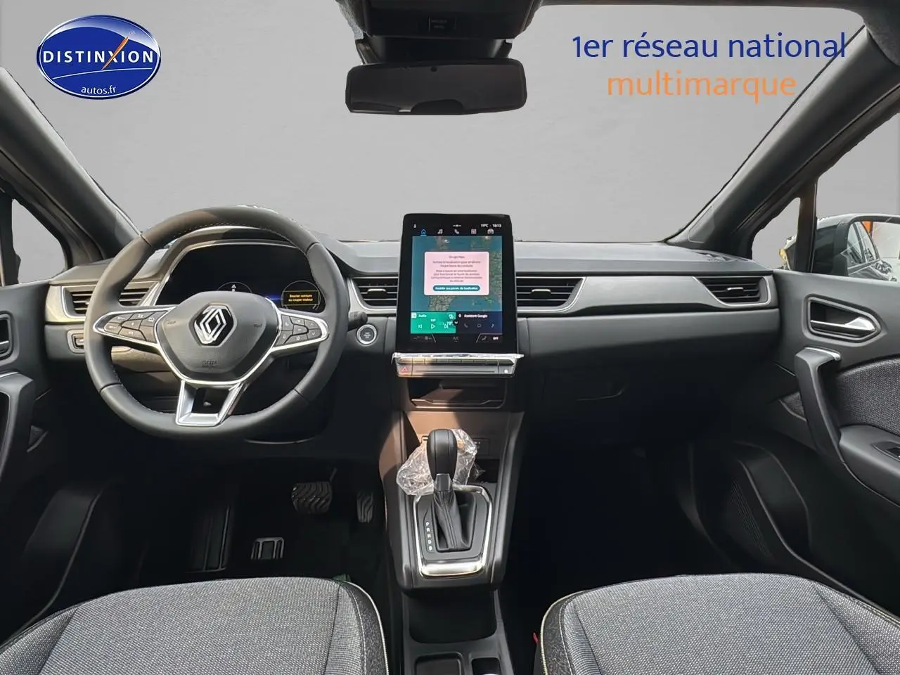 Intérieur avant du Renault Captur gris cassiopée 2025 avec écran tactile vertical et volant multifonction.