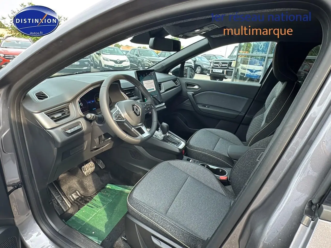 Intérieur avant droit du Renault Captur gris cassiopée 2025 avec sièges tissu gris et tableau de bord moderne.