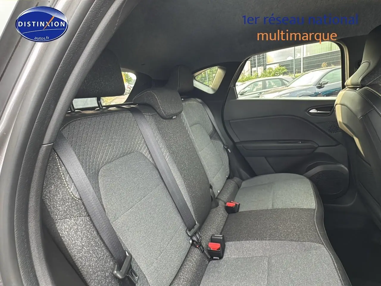 Vue intérieure côté droit sur la banquette arrière grise du Renault Captur 1.6 e-tech hybride 2025 avec ceintures et appuie-têtes.